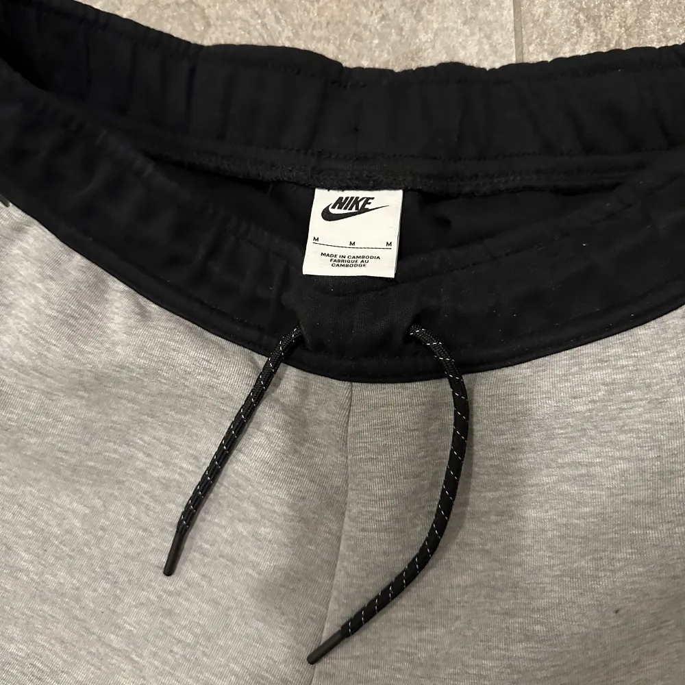 Nike tech fleece byxor i mycket bra Skick 9/10, färg svart och grå med vit logga. Storlek:M . Jeans & Byxor.