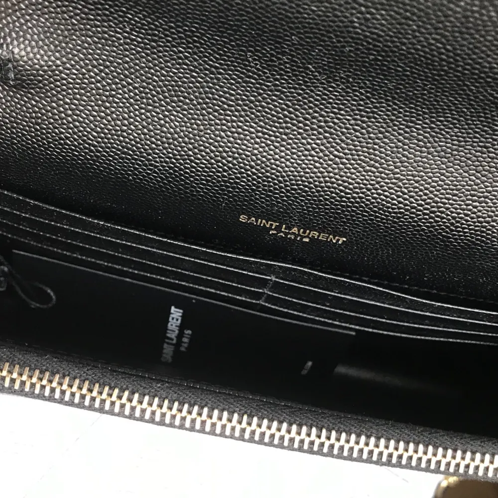 Yves Saint Laurent wallet on chain i mycket fint skick. Använd endast ett fåtal gånger med etiketten fortfarande kvar på. Väskan kan användas som axelväska, crossbody samt clutch. Innehåller en ficka samt 6 korthållare. Nypris ca 14.000 kr hos YSL.. Väskor.