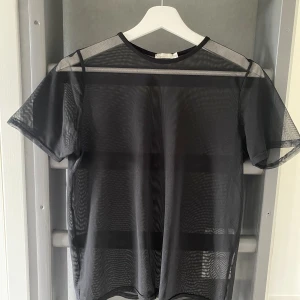 Mesh topp - Svart mesh top från Nelly.com. Storlek XS men oversized passform. Använd någon enstaka gång.