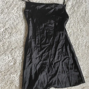 Svart satin klänning  - Gullig satin klänning som är är lite vid där nere vilket ger en fin effekt vid höfterna. Har inte strykit den på bilden så den är mer rynkig än den brukar vara 🙈fått av en kompis som köpt den på shein, men den är aldrig använd. 