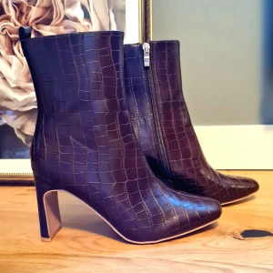 Stövlar med klack - Stövlar med klack i ormskinn-imitation. Stövlarna är veganska. 