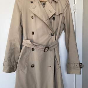 Klassisk trenchcoat från Burberry, 2 trasiga knappar, lätt att byta. Använd, men i fint skick