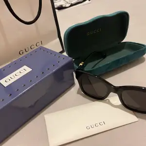 Svarta Gucci solglasögon med guld text 