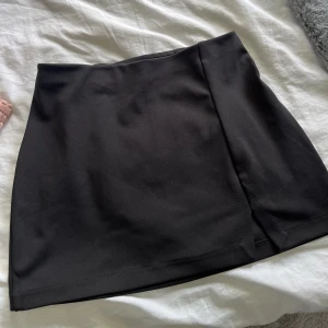 Svart kort kjol - Jättesöt svart kjol med liten slit!