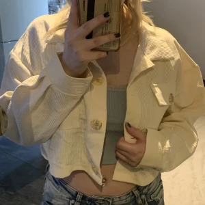 Jacka - En rätt så tunn och kort ribbad jacka med knappar. Den är vväldigt ljus beige/nästan vit. Storlek M, jag är S vanligtvis, därav lite stor.