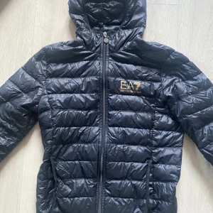 EA7 Emporio Armani jacka - Säljer nu denna EA7 jackan för att den inte passar min stil. Säljer billigt pga att jag behöver pengar snabbt. Skick 9/10 märks inte att den är använd då jag har tagit väldigt bra hand om jackan. Nypris: 2000