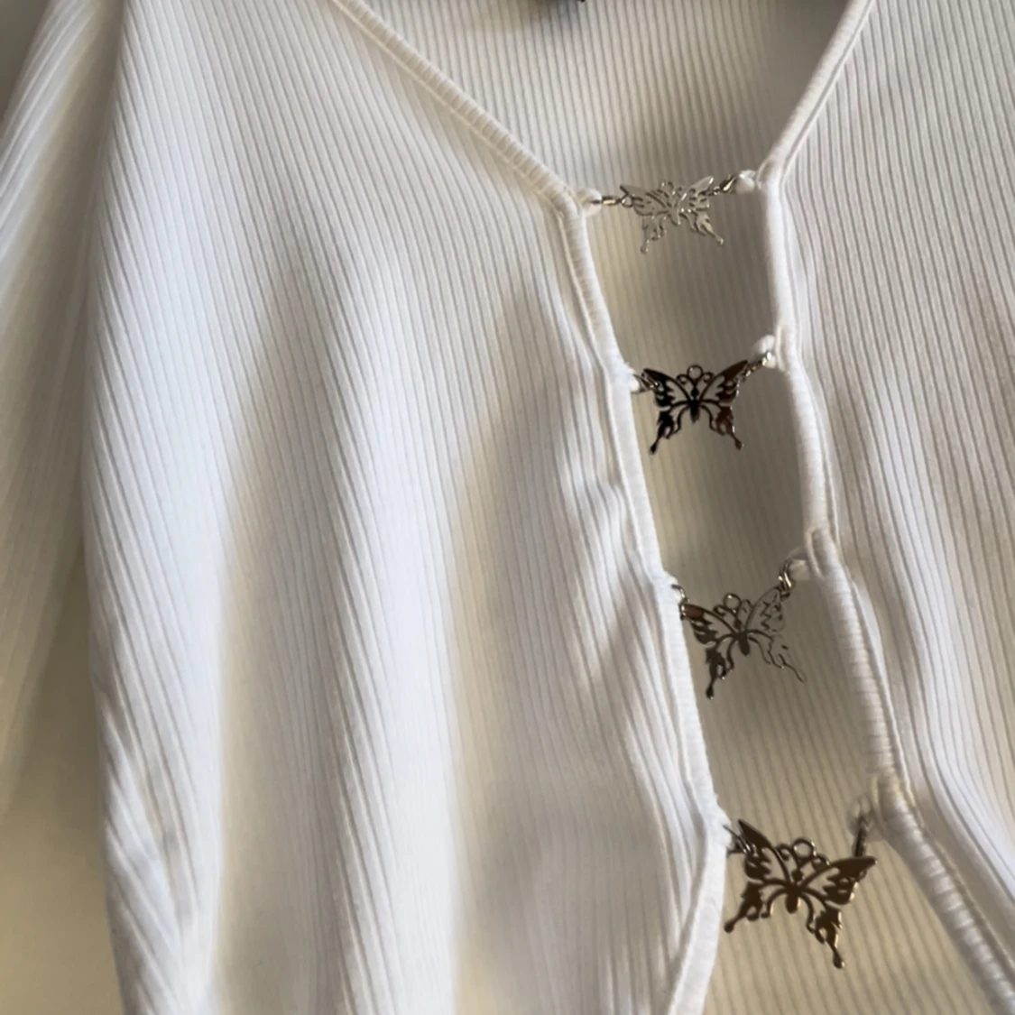 Vit topp med silver fjärilar