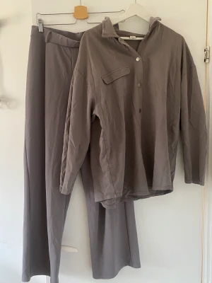 Mjukt Set - Grått mjukt set med skjorta och byxor. Använd fåtal gånger.  Skjorta är lite oversized.  Byxor: M Skjorta: L 