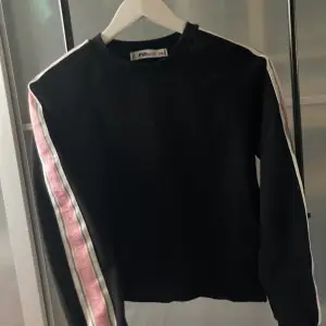 En supercool svart tröja med rosa och vita detaljer vid sidan av ärmarna. Jättefin att använda som träningströja ⭐️💗 (Aldrig använd) 