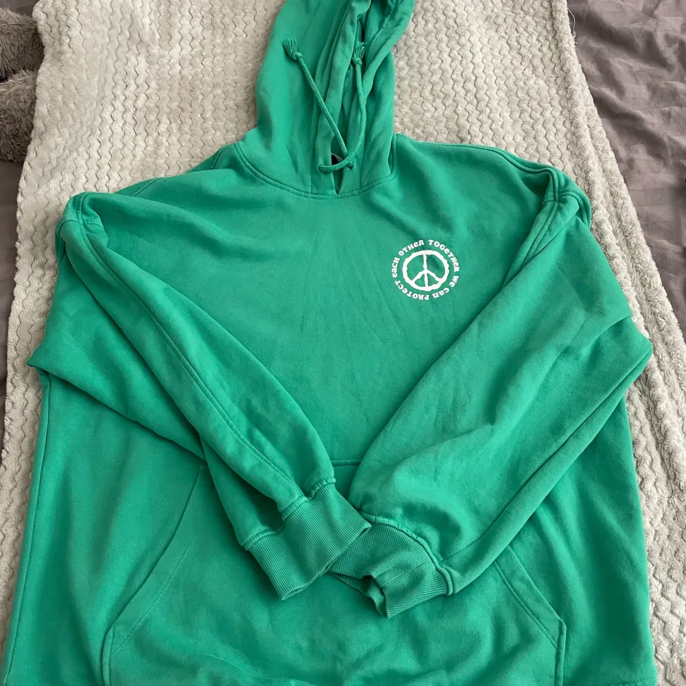 En grön hoodie med tryck på. Den är köpt på hm och är knappast använd. Kontakta mig om du har fler frågor . Hoodies.