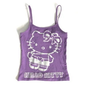 Hello Kitty Linne - Gulligt lila hello kitty linne! storlek 140 men passar förmodligen någon som har XS! (jag brukar ha S och den passar ändå) 💜OBS! linnet har ett litet hål i vänstra kanten. Hör gärna av dig vid frågor!