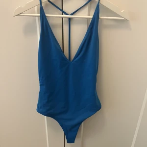 Blå baddräkt - Säljer denna snygga baddräkt från Topshop (köpt för 5 år sedan). Snygg korsdetalj baktill 🐳
