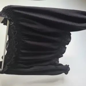 En svart långärmad off-shoulder tröja