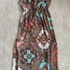 Långklänning, strl M - Långklänning av märket Sweet Storm i storlek M. Justerbar knytning i midja och nacke (bild 2 & 4). - Frakt: 60kr - TRYCK INTE PÅ KÖP NU