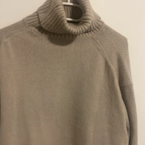 Stickad tröja  - En helt oanvänd stickad tröja med turtleneck 