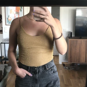 Glittrig body - Glittrig body i guld från H&M, aldrig använd 🧡