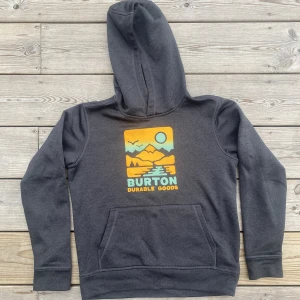 Hoodie - Mullig och mjuk kvalle i fint skick. Gummiprint i klara färger. Mörkgrå, nästansvart. 