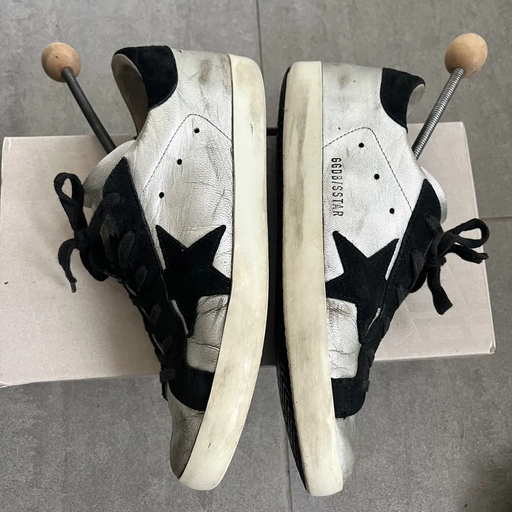 Hej! Säljer mina super fina silvriga Golden goose super-star sneakers. Stl 39. Väl använda samtidigt som slitningarna är en del av ”designen”. Har fler när bilder vid intresse. Ny pris 4800kr. ÄkthetBevis, ordinarie kartong samt dushbag medföljer🥰. Skor.