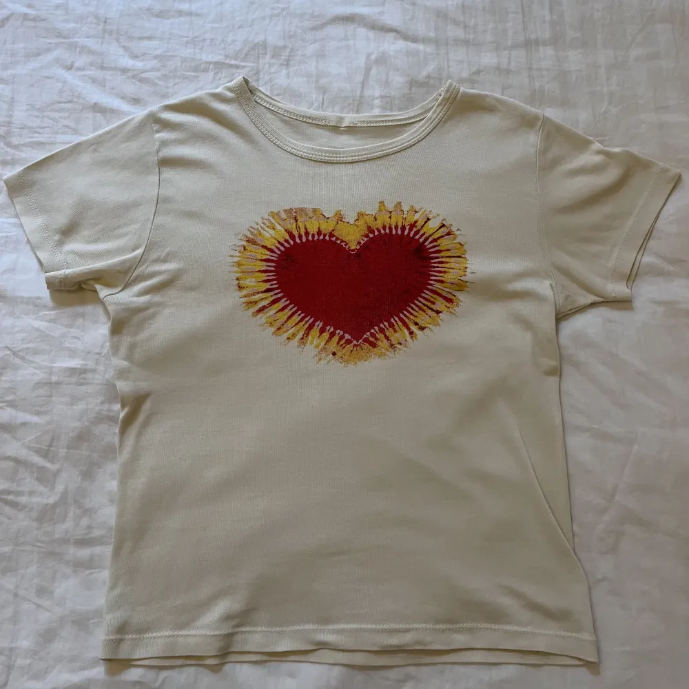 Beige t shirt med rött hjärta från urban outfitters. Gott skick men saknar lapp. Säljer via köp nu, skriv till mig vid minsta fråga!🩷. T-shirts.