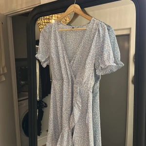 Klänning - Söt babyblå blommig klänning från nelly stl 36