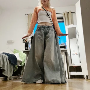 WEEKDAY JEANS - Extend jeans från Weekday! Blå jeans med mycket tyg på vänster sida för att kunna göra om dom till en kjol, finns hylsor för detta ändamål. Storlek 27, vilket mäter ca 75cm i midjan. Helt nya och oanvända! 