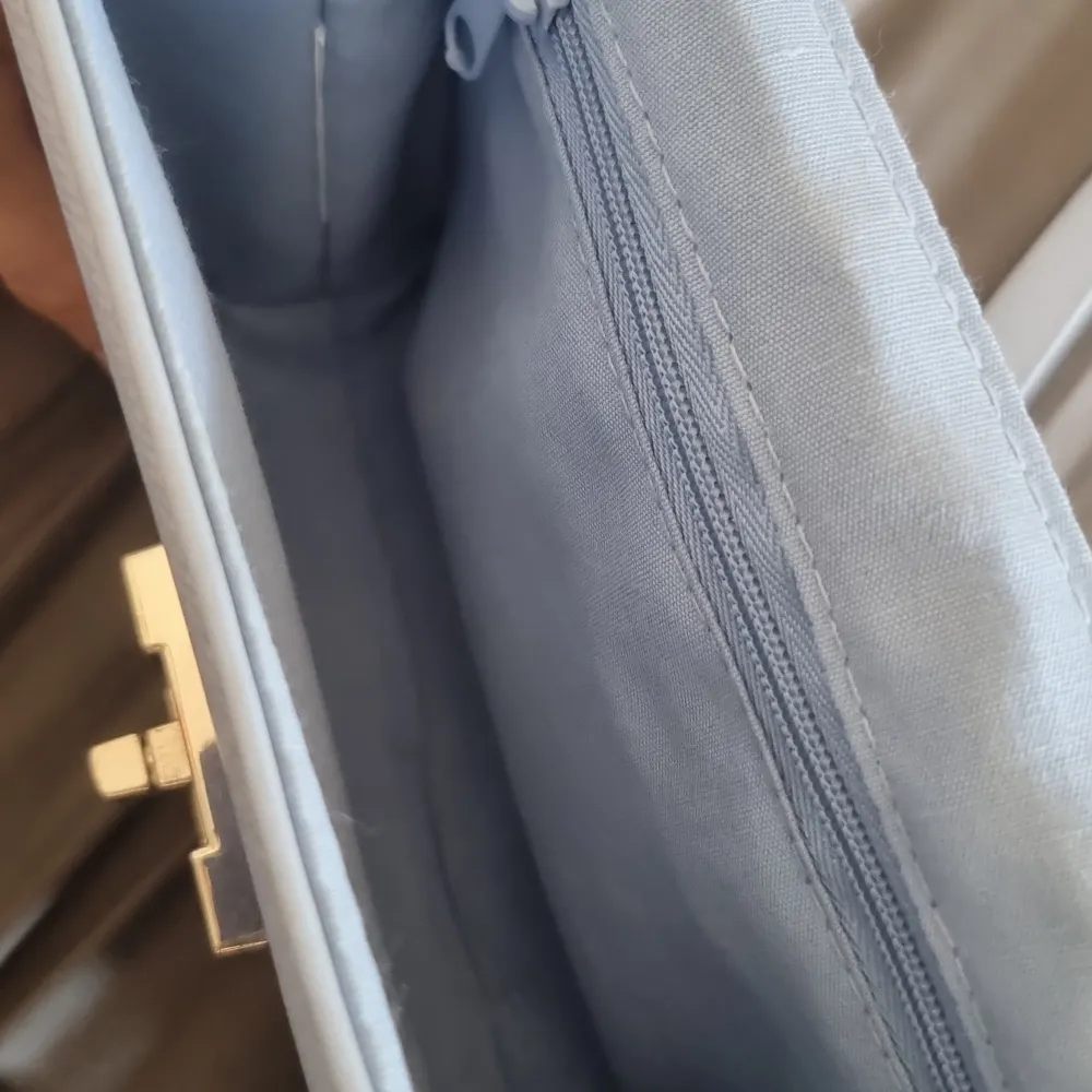 Söt blå axelväska, perfekt inför sommaren. Finns inga tydliga märken på användning. Den är ca 17cm lång och 9cm djup😊. Väskor.