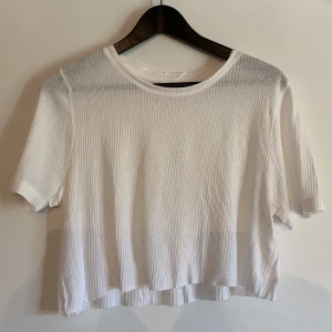 Vit crop top - Vit crop top med ”klippt”-lik slut från Ellen New York. Storlek 38. 