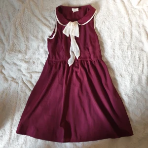 Seglarklänning vintage vibe - En söt vinröd seglarklänning från märket Pins And Needles med en vintage vibe. Inköpt från Urban Outfitters. Krage går att knyta eller göra rosett med.  Material: 100 % polyester. Luftigt tyg. Storlek Medium/M