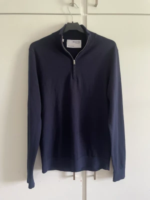 Half zip  - Marinblå stickad half zip i storlek S från Selected homme. Mycket bra skick, använd en gång bara. Där är någon söm bak vid nacken som är tunnare än resten av tröjan men syns typ bara om man kollar nära. 50% polyester och 50% merinoull. Nypris 699 kr.
