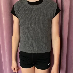 Stickad vest - Jättefin stickad och mörkgrå vest som knappt kommit till användning! Materialet är runt stickat som passsar perfekt att ha över t-shirts när det är lite kyligare!