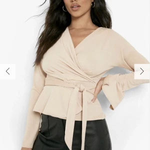 Wrap topp - Topp med slitsade ärmar. Nyskick. Aldrig använd. Storlek 36 men funkar för 34. Inköpspris: 299kr 