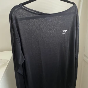 Gymshark oversized tröja S - Genomskinlig träningströja från gymshark, svart i storlek S med en oversized fit.  Skick: aldrig använd med orginalförpackning.   Nypris: 299kr