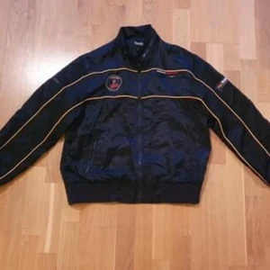Ballaste bomberjackan från Crocker!  - Racingjacka från Crocker! Snygga patches: Ett på högra bröstet där det står "Cobra - Ultimate Speed Racer", ett på vänstra bröstet där det står "Formula One" och ett på vänstra ärmen där det står "Rider - The Monte Carlo Competition". Fint skick! 