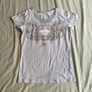 Hard rock couture tee  - Grå Hard Rock Couture (hr café) New York tisha med ”diamanter”, guldsöm och ascool baksida. Några stenar är borta men annars har den inga defekter. Säljer pga att den inte är min stil