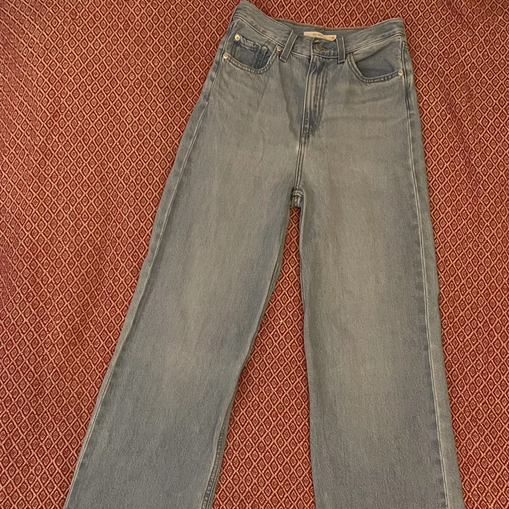 Hög midja och vida ben. Ljusblå Levi’s jeans i strl 25 - midja 25, längd 33.  Köpta för 1695 kr. Endast provade och tvättade en gång.. Jeans & Byxor.