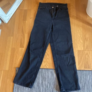 Jeans - Svarta jeans med slit på utsidan. Straight leg. Hög midja
