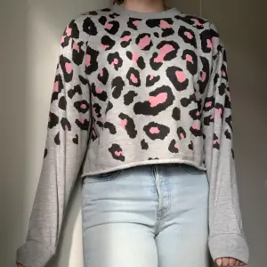 Grå croppad sweatshirt med cheeta-print. Man visar inte magen om man inte sträcker på armarna. Supermjuk och mysig insida. 