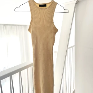 Kort klänning med blommor  - Söt sommarklänning med broderade blommor från bershka! Använd en gång och är i fint skick. Formar sig efter kroppen 🌼🌼🌼