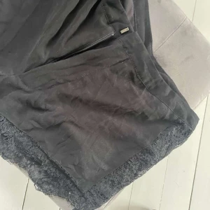 Shorts  - Tyg shorts med spets detaljer på sidan o längst ner 