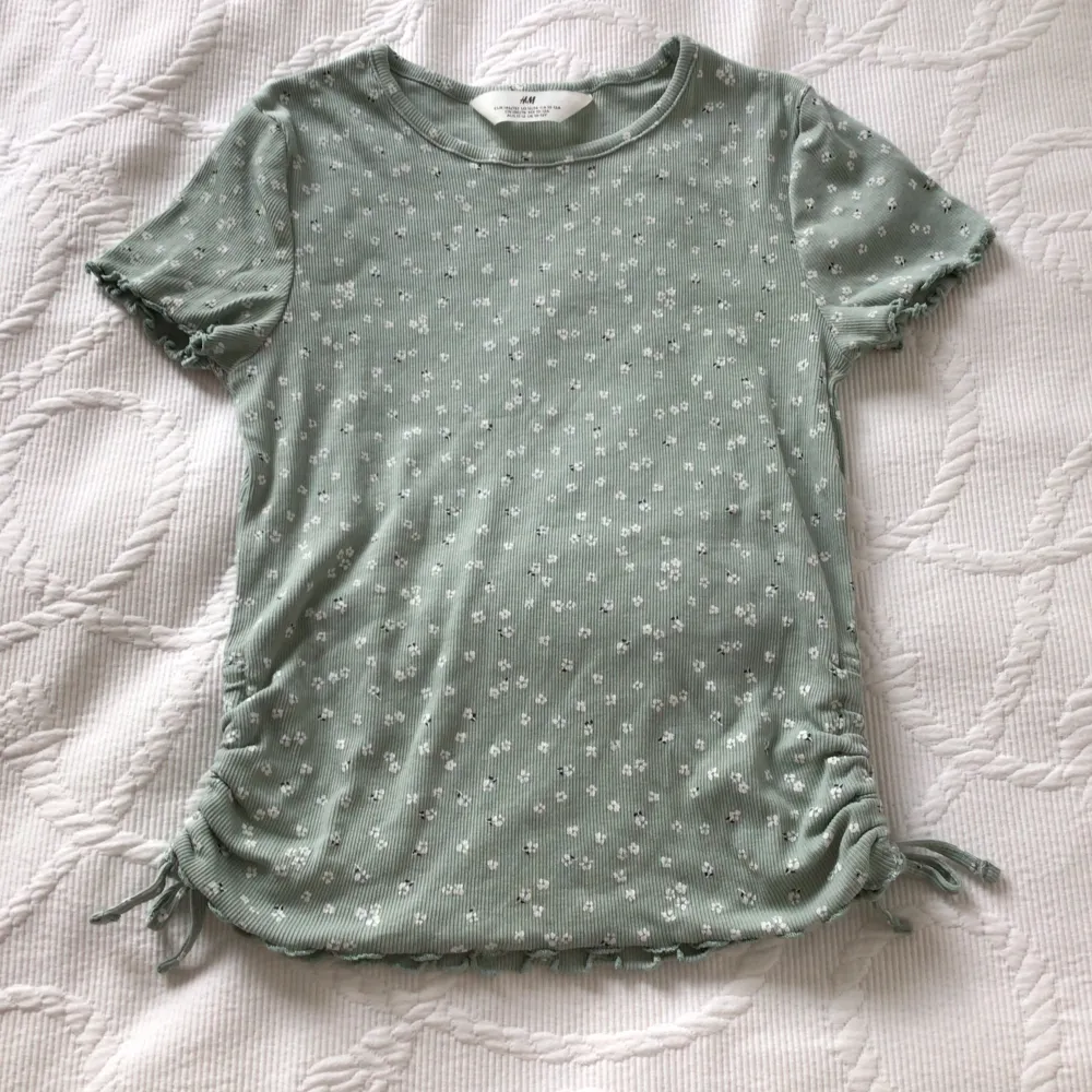 Supeeerfin blommig grön T-shirt!💞💐 Inte riktigt samma färg som på bilderna,  den är mer ljusgrön irl, inte så mintgrön som de är på bilderna💘😻 Sparsamt använd, tror den är använt typ en gång! Inga fläckar eller hål🪩🍸 Storlek 10-12Y🫶🏼🫶🏼🫶🏼. T-shirts.