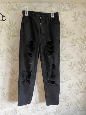 Jeans  - Ett par svarta jeans med hål i,(det ska vara så). 