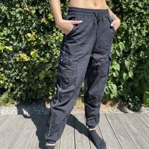 Iprincip oanvända adidas trackpants/cargopants. Fickor på sidorna och strecket på sidan är i reflex. Bara å höra av dig om du vill ha fler bilder eller har någon fråga 🥰