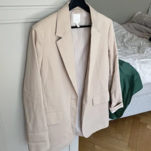 Kavaj från HM - En beige kavaj från H&M, inköpt 2022. Använt fåtal gånger, perfekt basplagg.   Jag är vanligtvis en S och på mig har den varit lite oversized, har tex haft den över en klänning osv. 