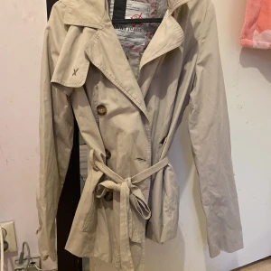 Beige kappa - Vanlig basic beige kappa. Den är kort slutar ungfär mellan låren