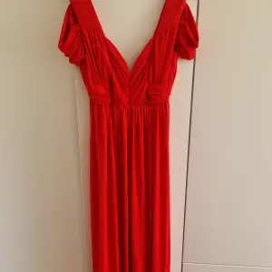 Röd långklänning med slits. Från ASOS, storlek 38/S-M. Aldrig använd! Fint material som ej blir skrynkligt.