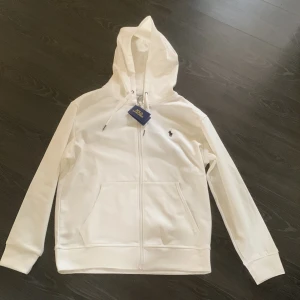 Ralph Lauren Zip Vit - Säljer nu denna vita ralph lauren zip hoodie eftersom den inte passar mig. Storlek Large. Kom dm för funderingar😊
