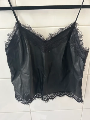 Linne från Bikbok  - Fint svart linne i läderimitation från Bikbok! Storleken är M jag bär S och det är något stort för mig i banden tyvärr säljer därför den! 