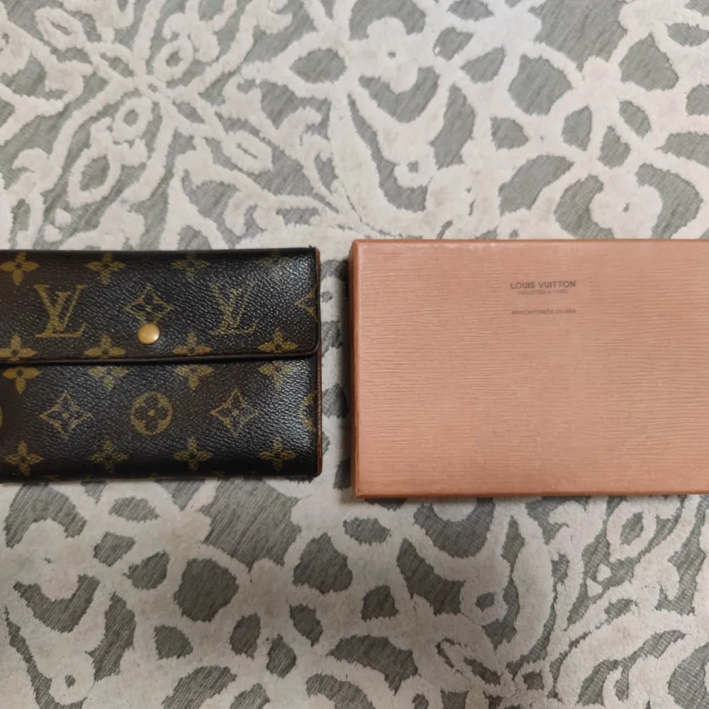 Unisex Louis Vuitton monogram Wallet och tillhörande original låda.   Fick den i present för en bra stund sen så finns inget kvitto dessvärre.  Knappen för att stänga är lite slö och den har signs of use (där av priset) men överlag fortfarande fin.   . Väskor.