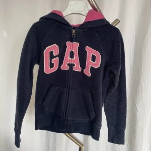 Marinblå gap flis  - Marinblå gap flis med rosa detaljer. I fint använt skick. 8-9 år (128-134). 