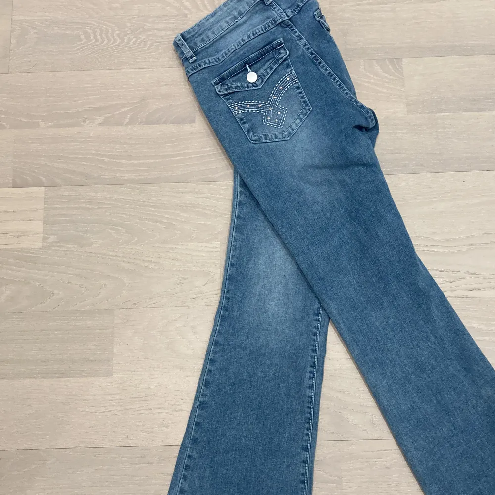 Blåa utsvängda blåa jeans, med tryck på fickorna. Bra skick andvända få gånger.. Jeans & Byxor.